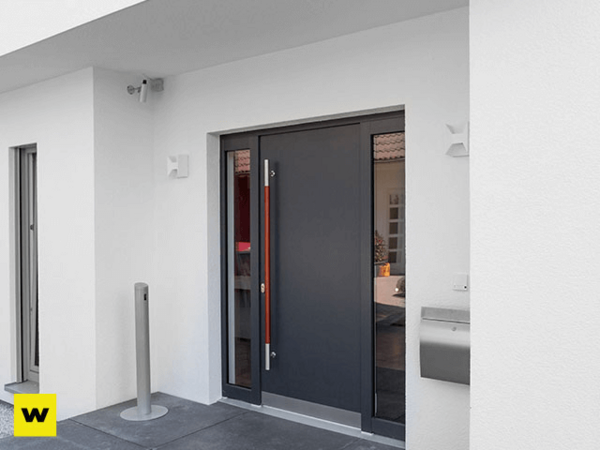 Moderne Haustür in Anthrazit mit Seitenteil an einem weißen, energieeffizienten Neubau.